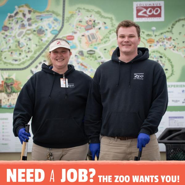 Two team members standing in front of the Columbus Zoo map, smiling